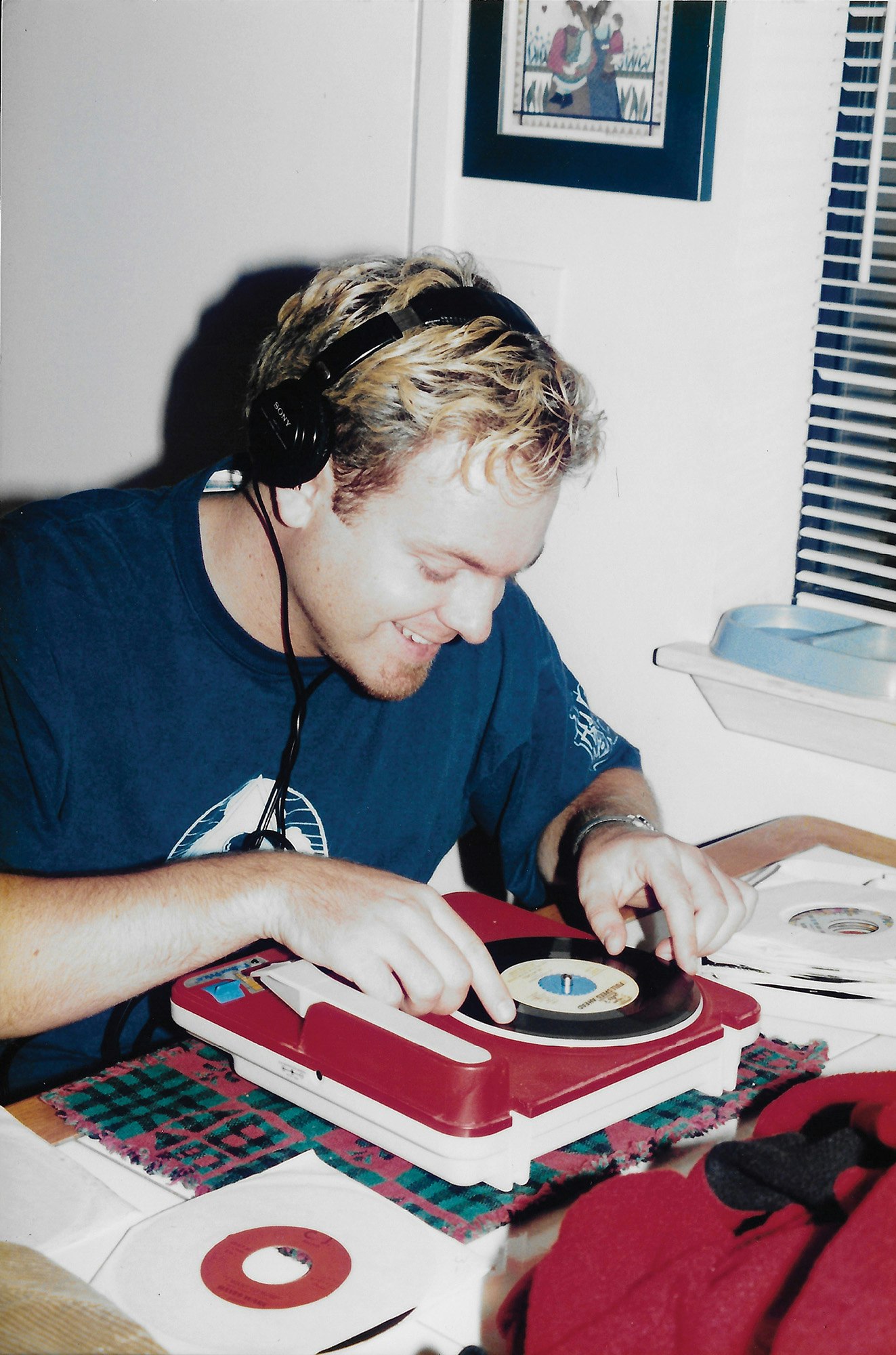 DJ Shadow in 1996 with his portable Turntable, listening to records purchased on a digging trip in the central valley. Photo courtesy of Josh Davis.